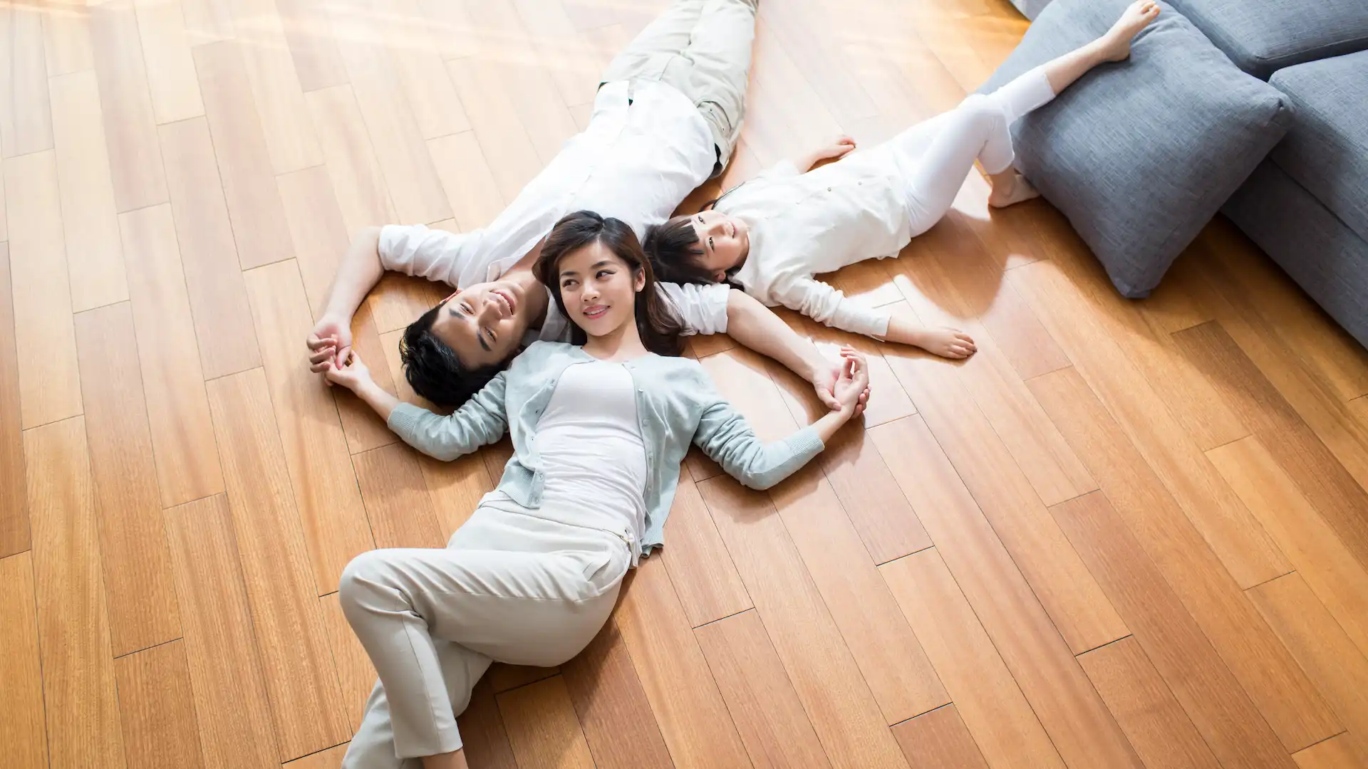 happy young family resting on wooden floor