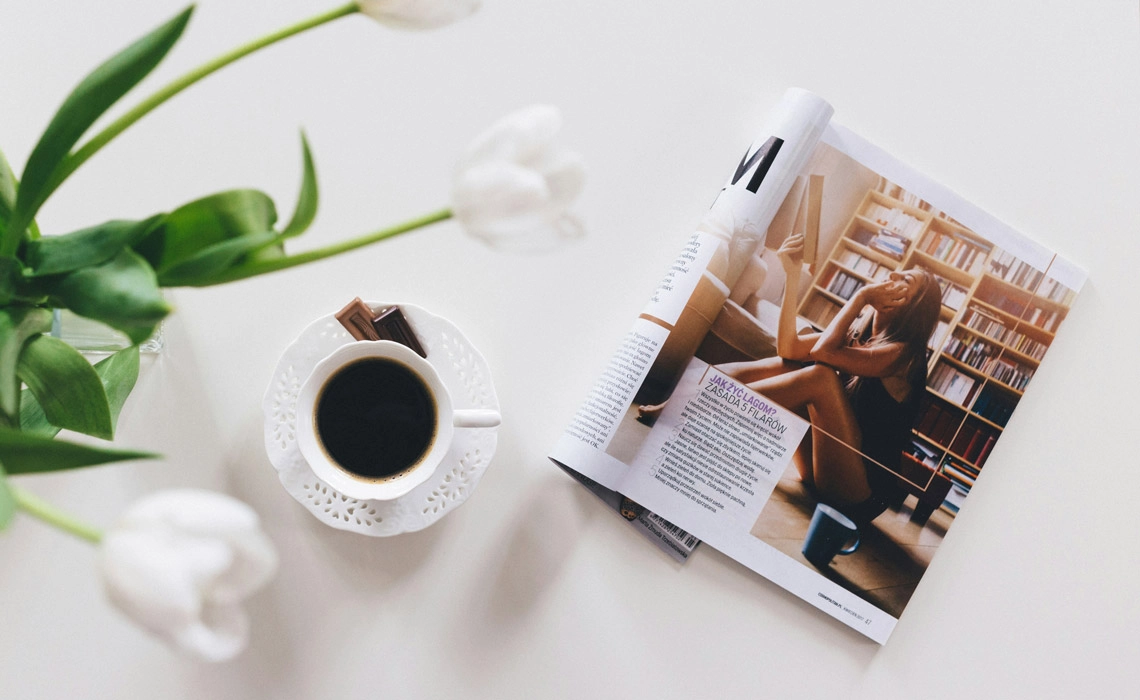 Coffee beside open magazine