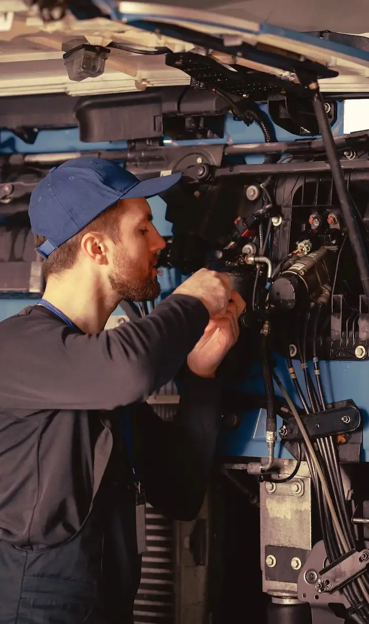 mechanic repairs blue car in garage