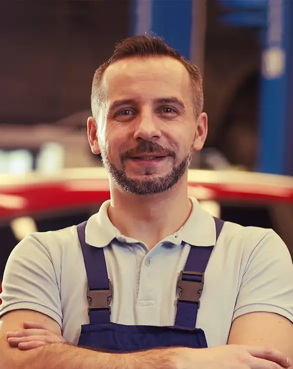 mechanic posing with red car