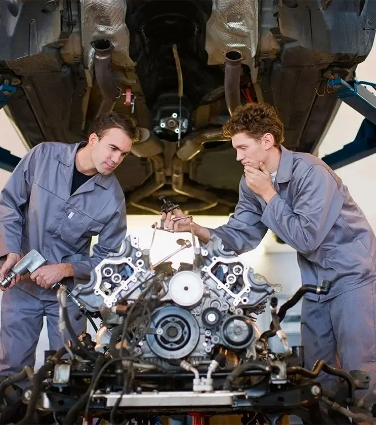mechanics working on car engine